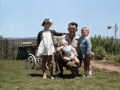 Hendrik Lodewyk Malherbe "Hennie" Oosthuizen (1909-1979) kneeling on the grass with three of his children: FRANCES...
