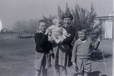 The four children of Hennie Oosthuizen and Anna Joubert, on the werf. FRANCES stands in the middle in a tartan skirt...