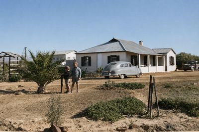 The homestead at Vischat: a low gabled house with a corrugated-iron roof and a verandah on two sides, outbuildings...