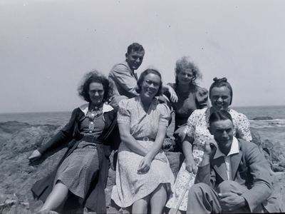 Six young people on the rocks above the sea. Frans Oosthuizen identifies three of them: TOKKIE MARINCOWITZ sits at...